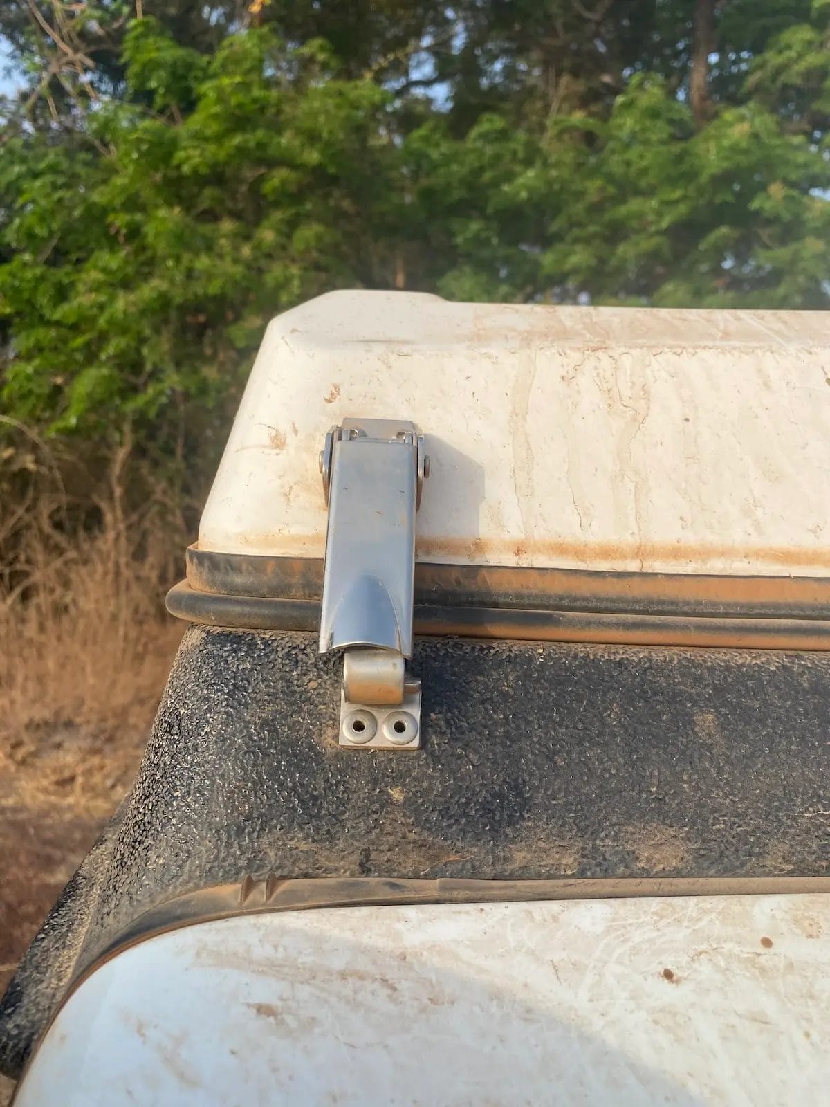 Front locking bracket securing an Ursa Minor pop-top camper to a Jeep Wrangler.
